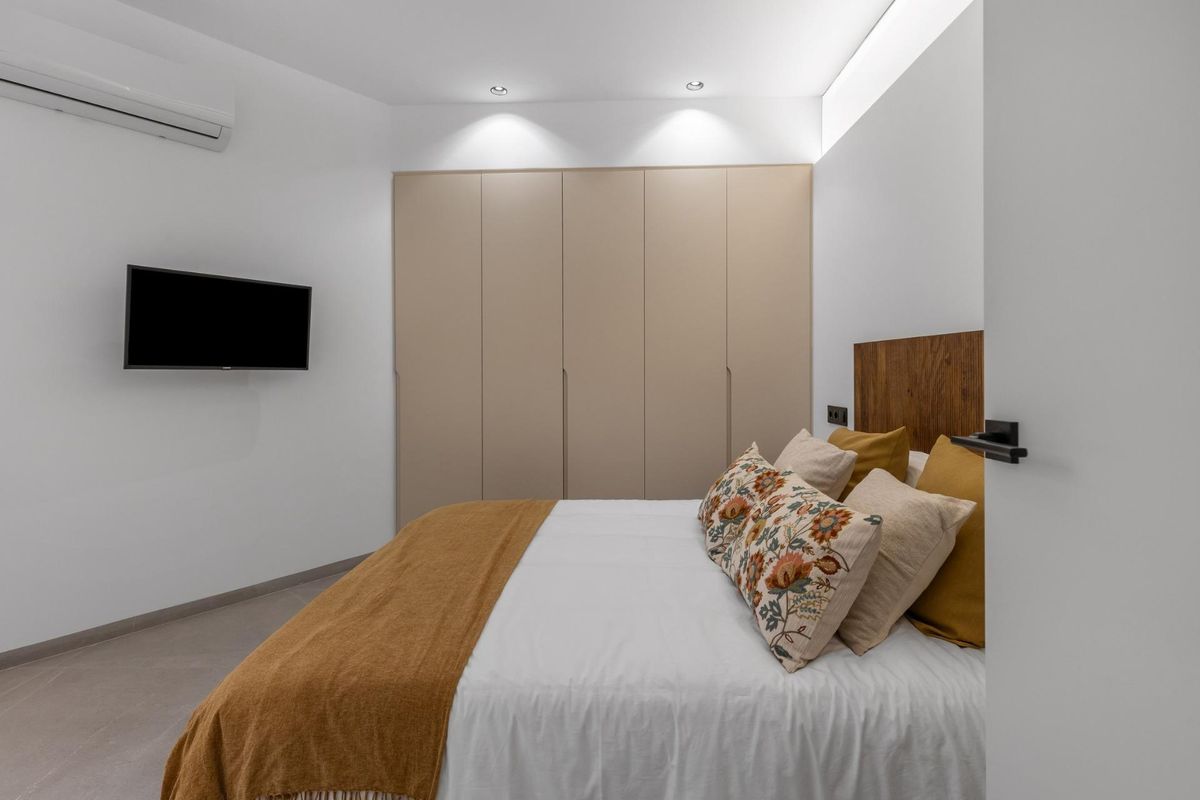 Gezellige slaapkamer met een comfortabel bed en moderne kast in een 1-slaapkamer appartement, Torrevieja.