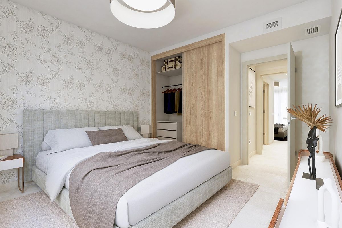 Gezellige slaapkamer met bloemenbehang en voldoende opbergruimte in een 2-slaapkamer appartement in Mijas.