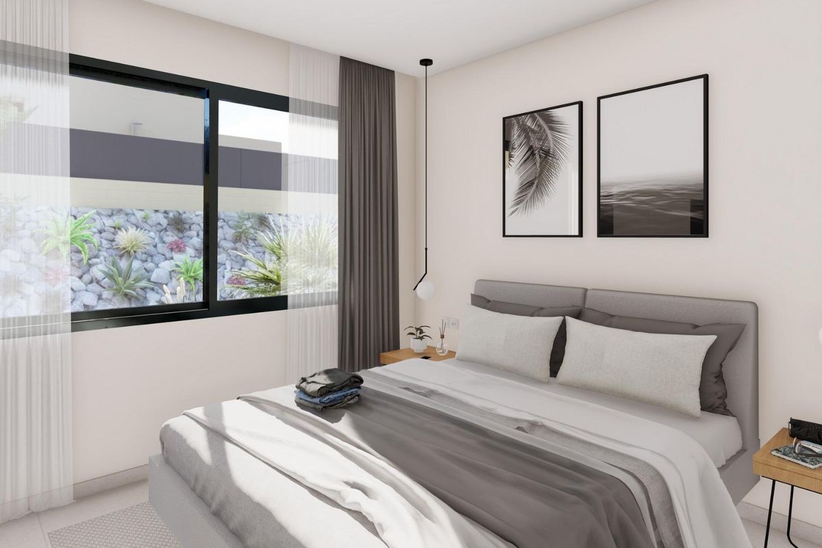 Stijlvolle slaapkamer met strakke meubels en uitzicht op de tuin in een 3-slaapkamer villa in Baños y Mendigo.