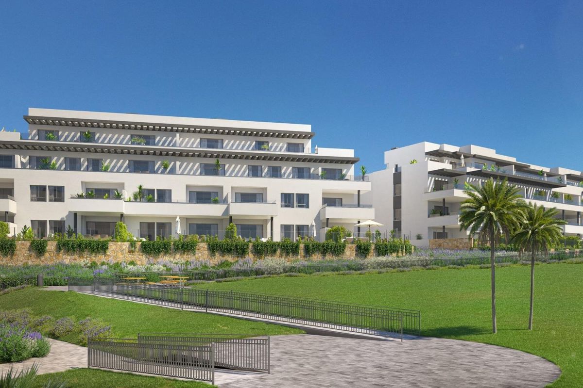 Grondfoto van een modern appartementencomplex met groene terrassen in Mijas, Costa del Sol, dat buitenleven bevordert.
