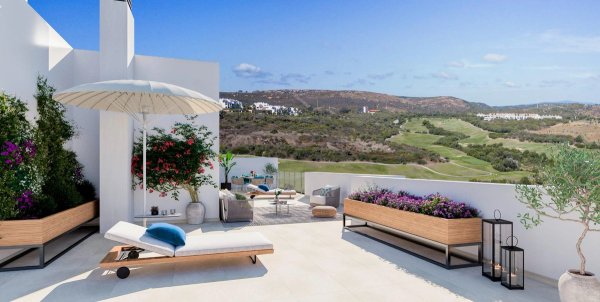 Ruim terras van een 3-slaapkamer penthouse in costa del sol, spanje, met loungebanken, planten en uitzicht op het omliggende landschap.