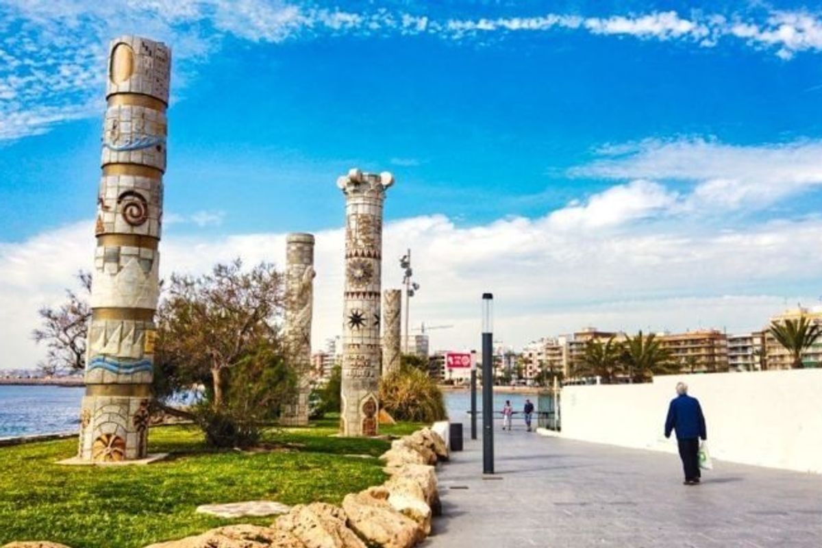 Cultureel monument in Torrevieja, met decoratieve kolommen langs een schilderachtige oeverpad.