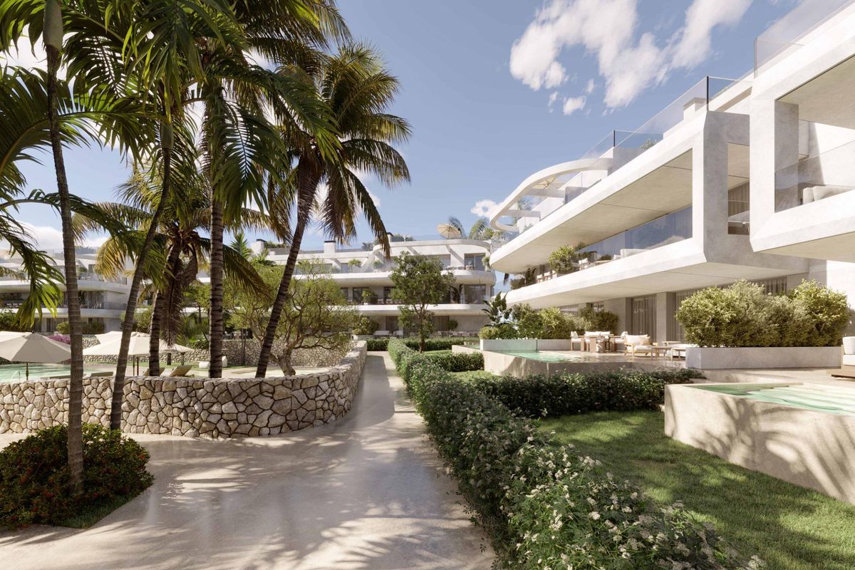 Pad dat door tuinen tussen moderne appartementen in Estepona, Costa del Sol, leidt.