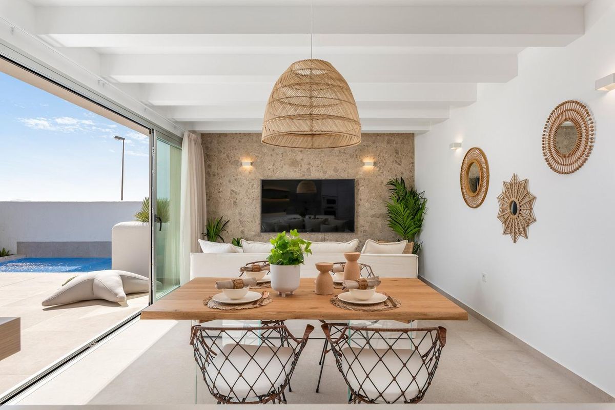 Gezellige eetruimte met een grote tafel en zitplaatsen bij een stijlvolle tv-ruimte in een villa in Los Alcazares.