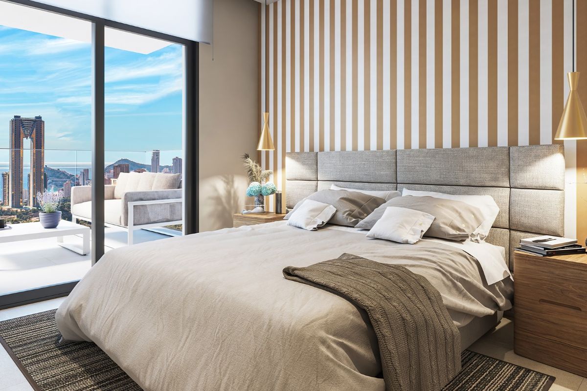 Stijlvolle slaapkamer met grote ramen en een prachtig uitzicht op de skyline van Benidorm.