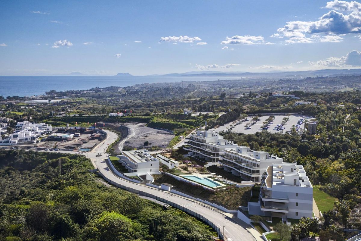 Luchtfoto van nieuwe appartementen met zwembad en parkeren, met groene omgeving in Estepona, Costa del Sol.