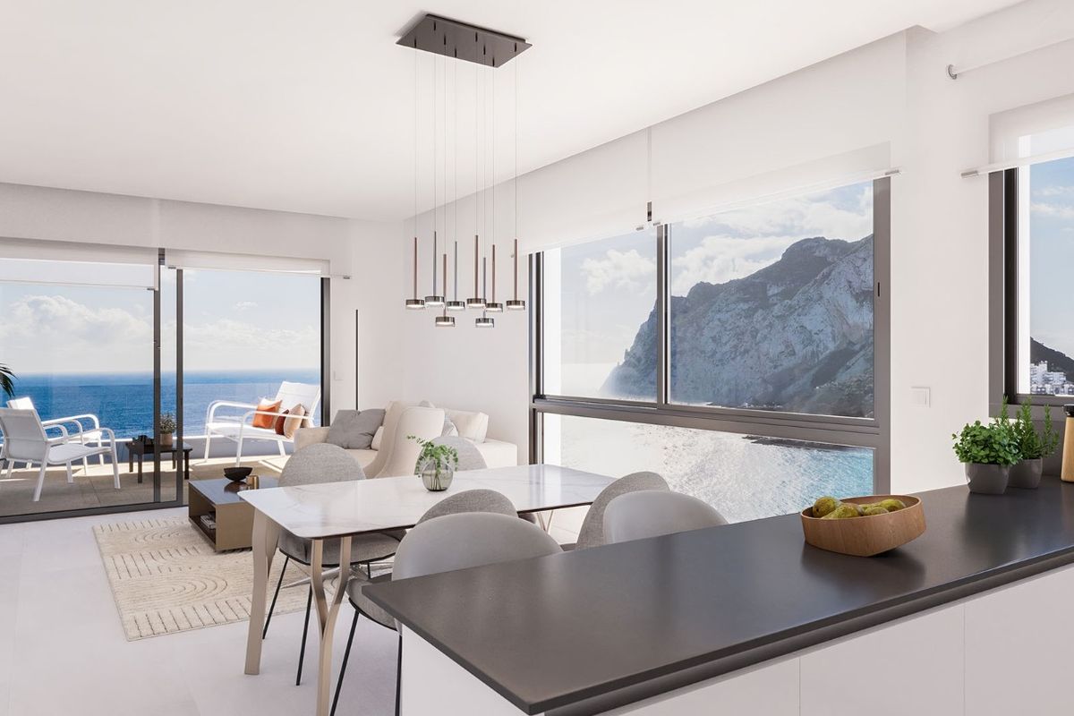 Heldere eetkamer met uitzicht op zee en een open keuken in een 3-slaapkamerappartement in Calpe.