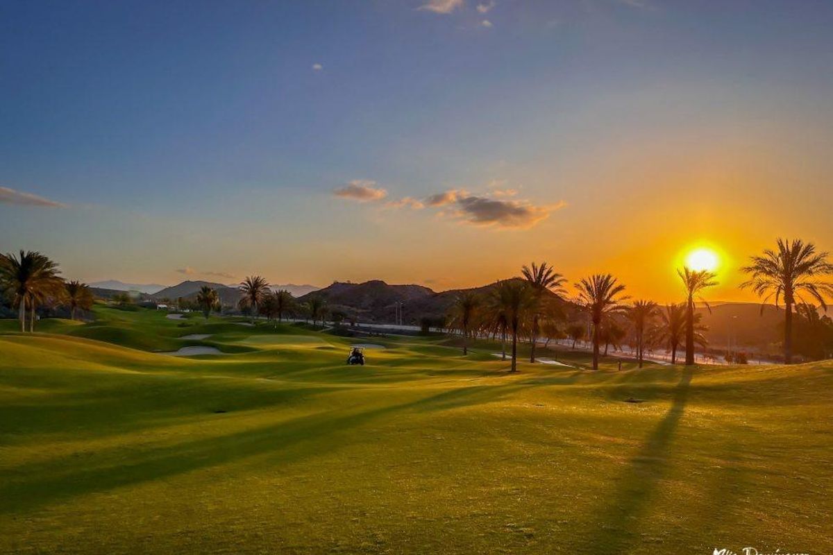 Zonsondergang boven een golfbaan in Pulpi, Costa de Almeria, met palmbomen en schilderachtige landschappen.