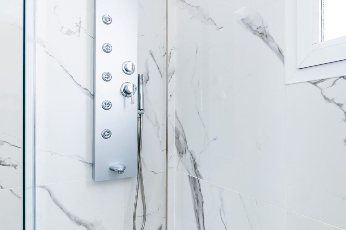 Luxurious shower area featuring modern fixtures and marble walls in the villa.