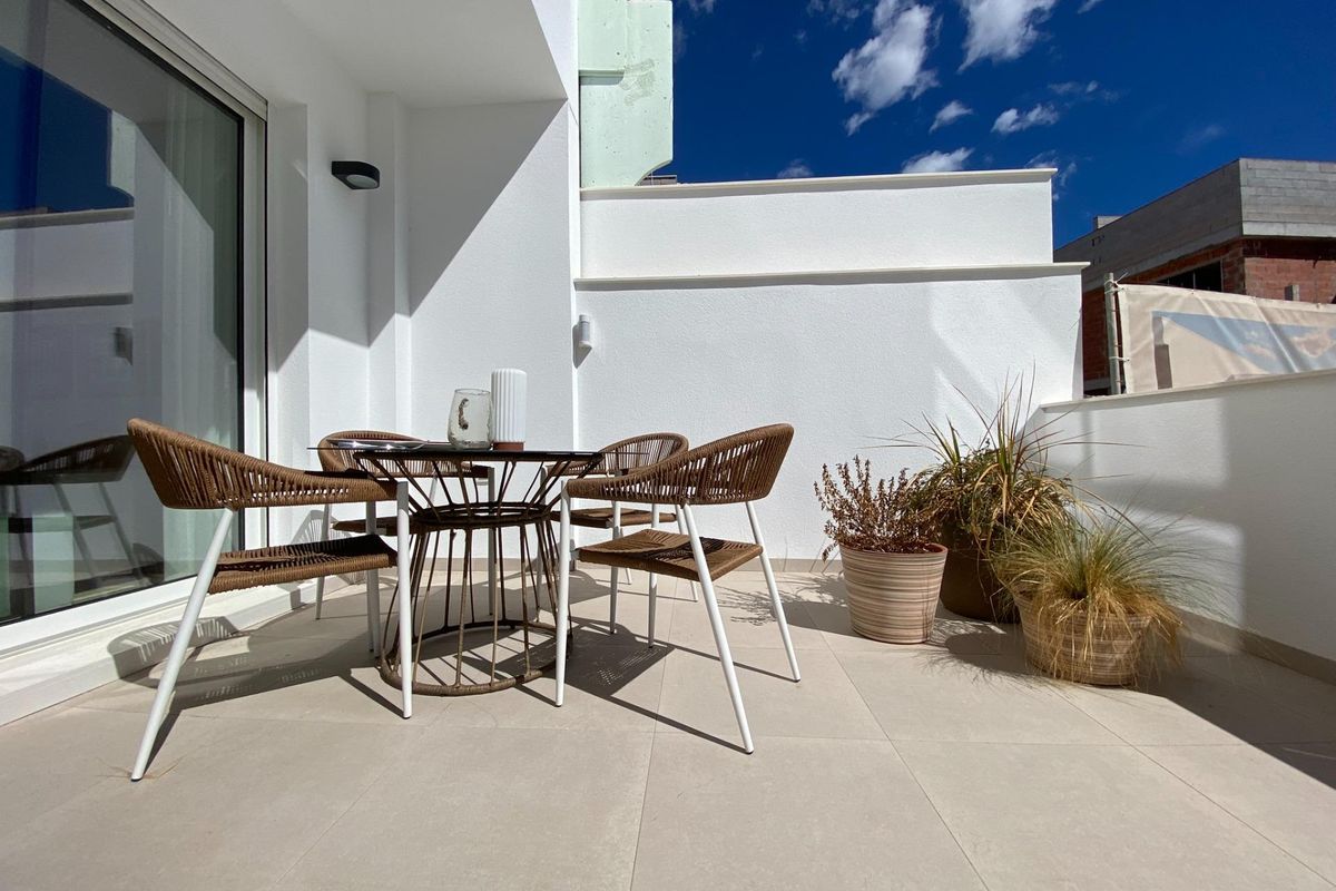 Gezellige terraszitplek bij een 3-slaapkamer appartement in Pilar de La Horadada met planten en zonlicht.