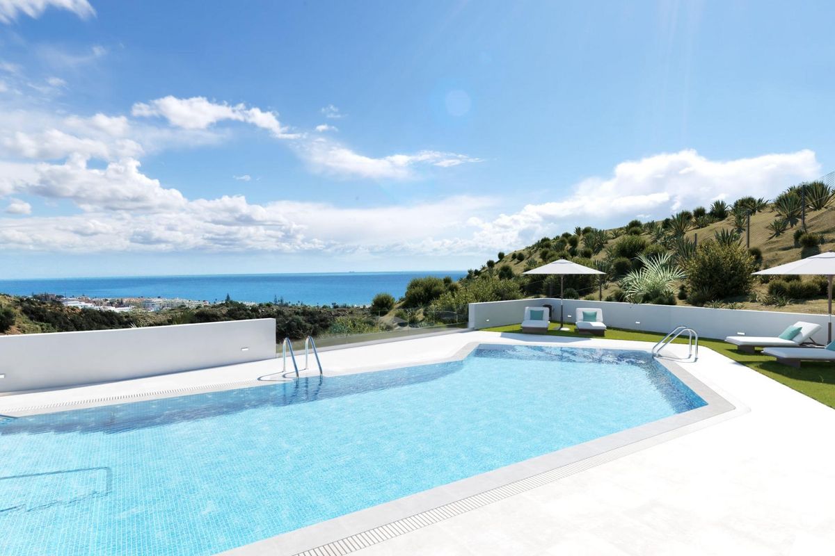Zwemmenpool met ligstoelen en zeezicht in Rincon de la Victoria, Costa del Sol.