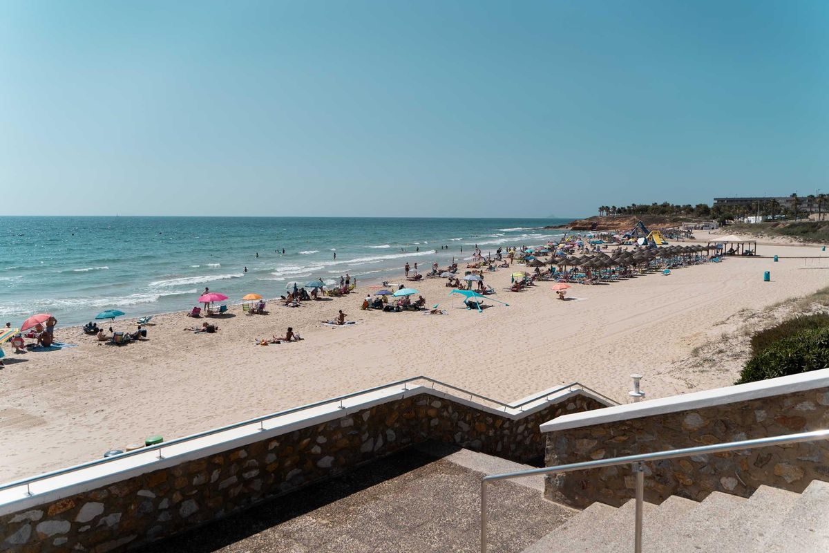 Schilderachtig uitzicht op het strand vol zonnebaders en parasols nabij Pilar de La Horadada, ideaal om te ontspannen.