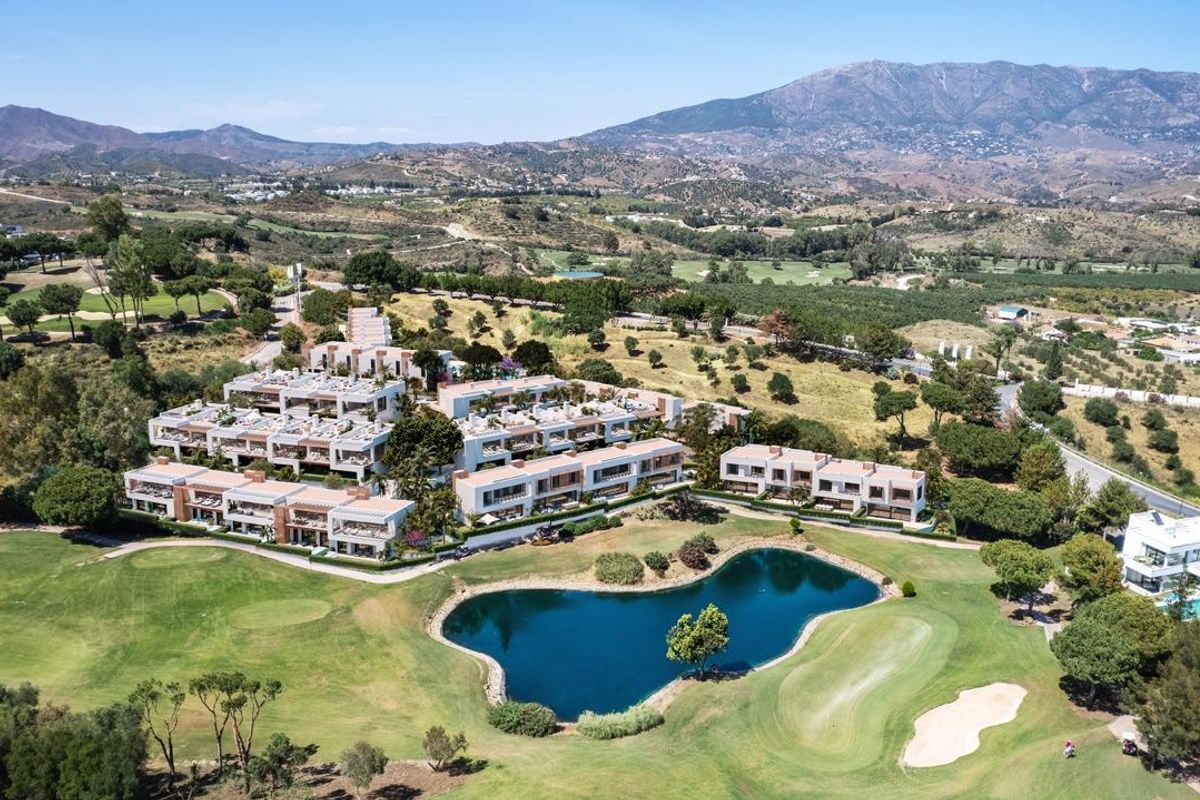 Luchtfoto van een luxe gemeenschap in Mijas, Costa del Sol, omringd door golfbanen en natuur.