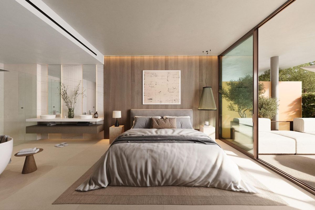 Stijlvolle slaapkamer met grote ramen en luxe badruimte in een appartement in Fuengirola.