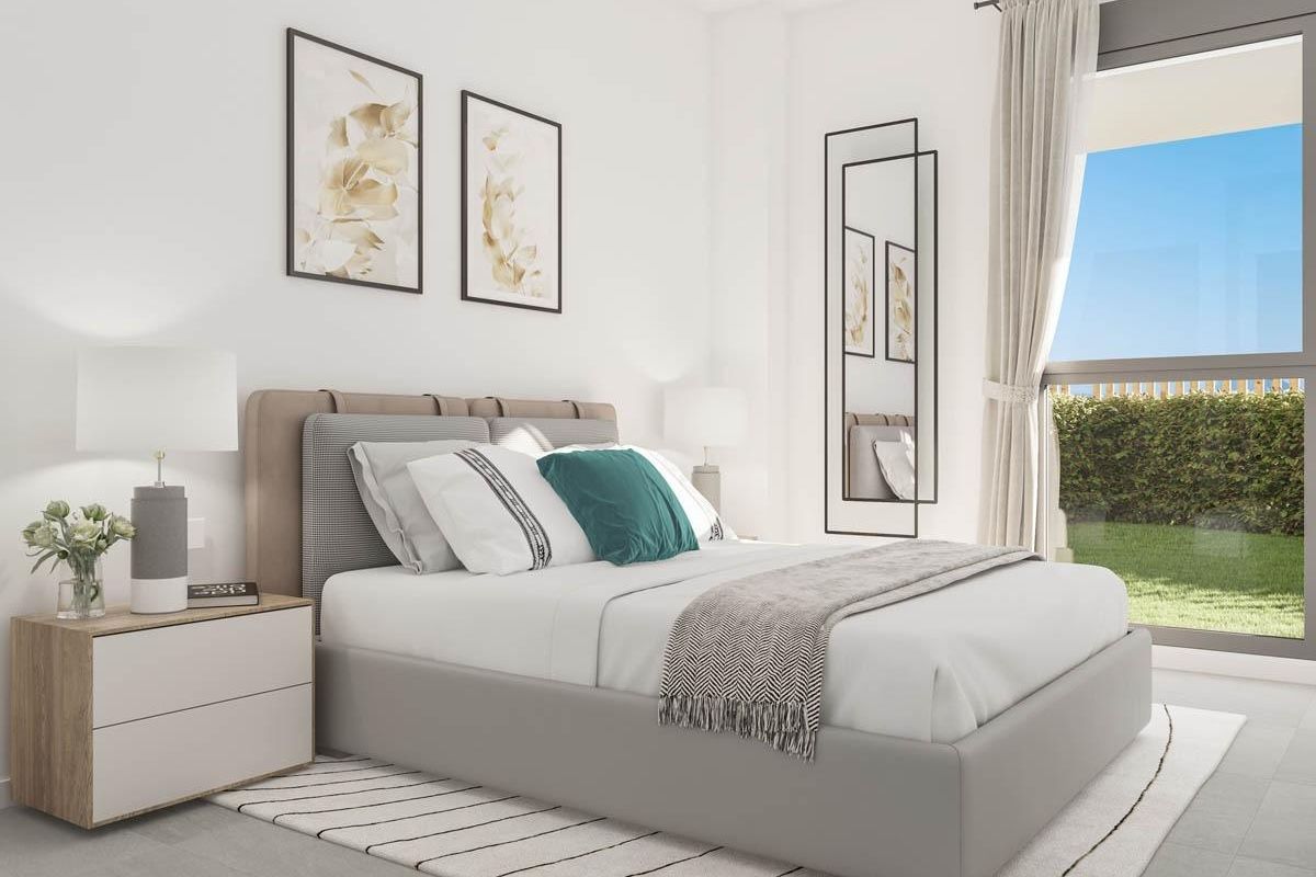 Moderne slaapkamer met witte muren, grijze bedbank en turquoise sierkussen in Manilva-stadswoning