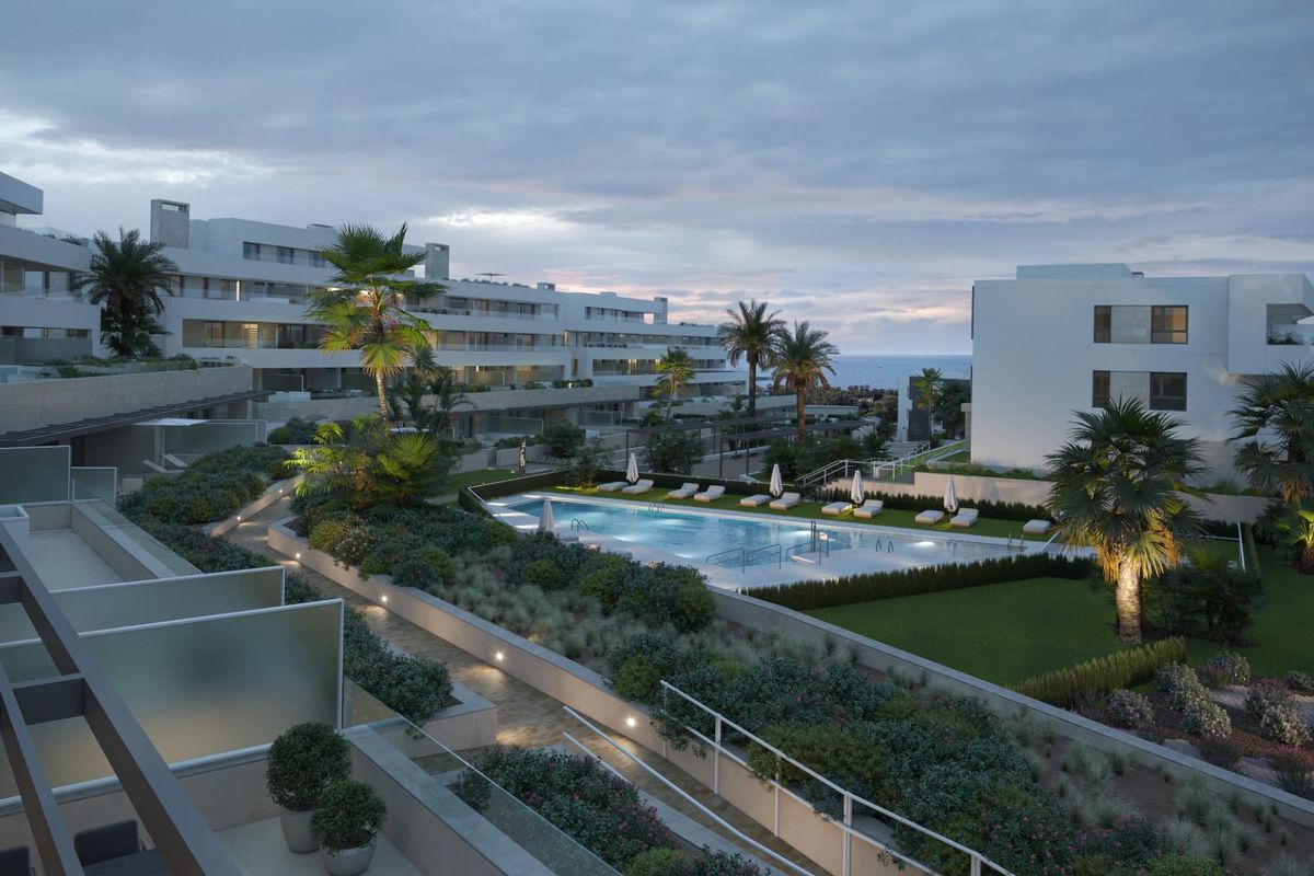 Avondzicht over het zwembad en de tuin in het moderne 3-slaapkamer appartement complex in Estepona.