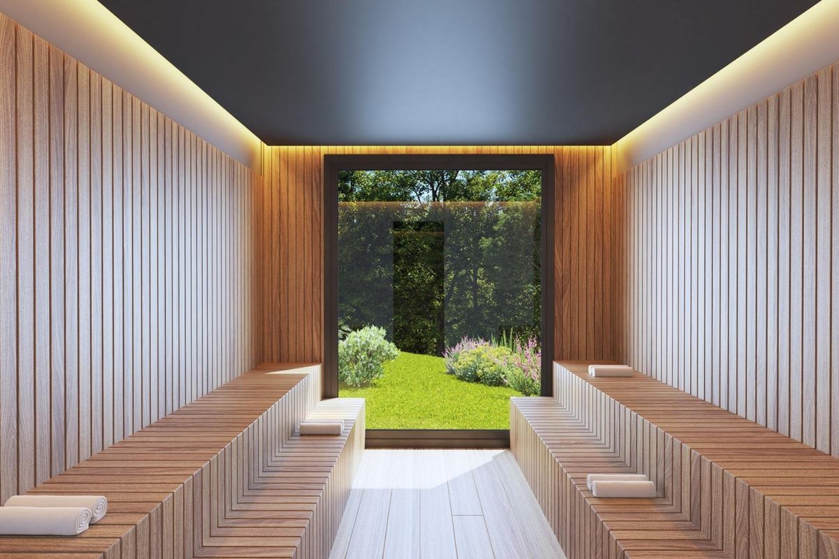 Moderne saunaruimte met tuinzicht in Mijas woning. Met houten banken, wandpanelen en helder tuinzicht.