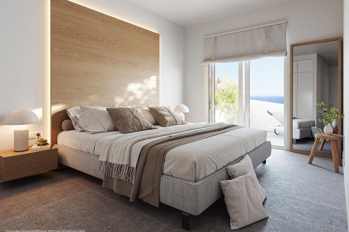 Gezellige slaapkamer met een groot bed en uitzicht op zee, gelegen in een appartement op de begane grond in Mijas, Costa del Sol.
