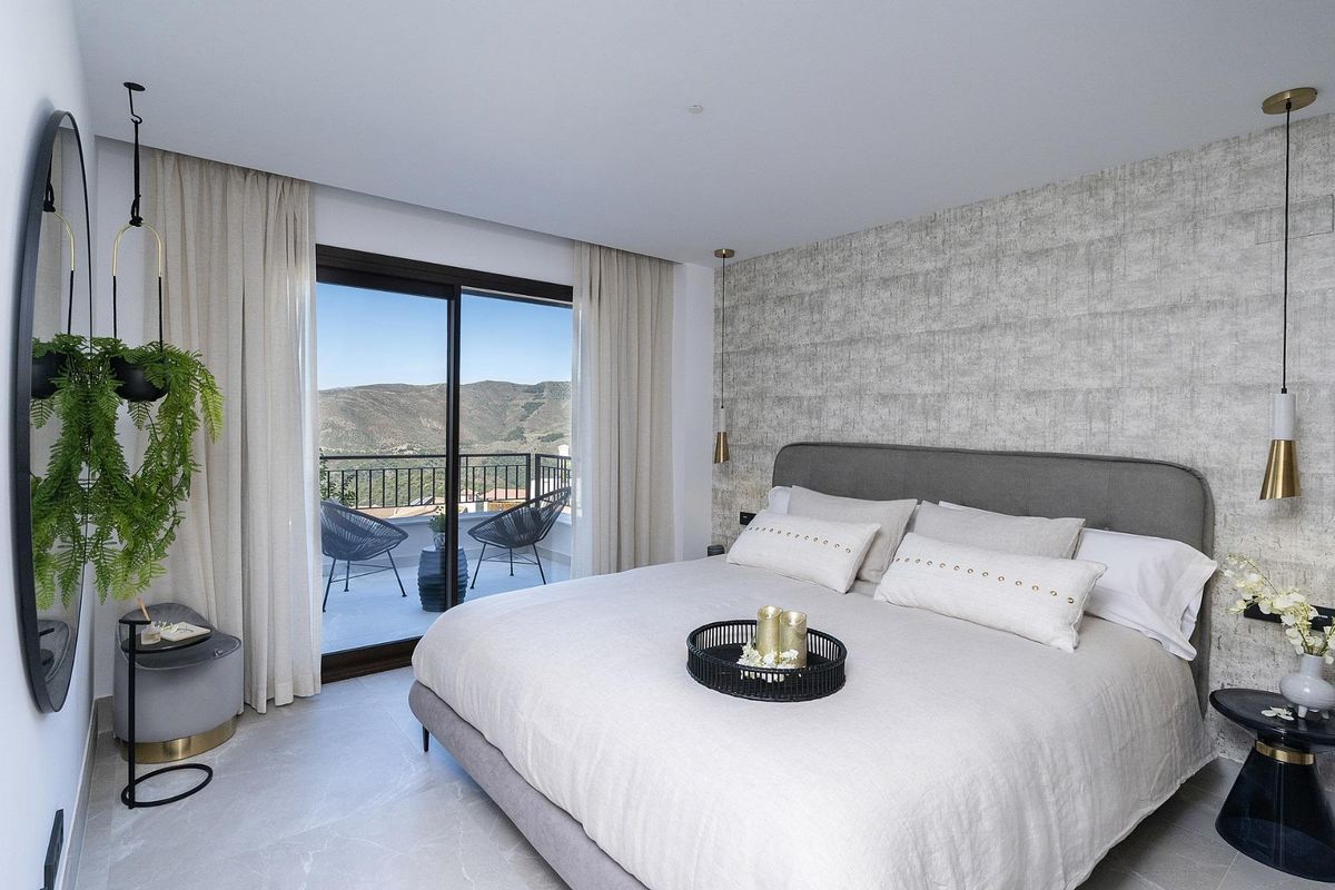 Heldere slaapkamer met balkonuitzicht in een modern penthouse in Istán, Costa del Sol.