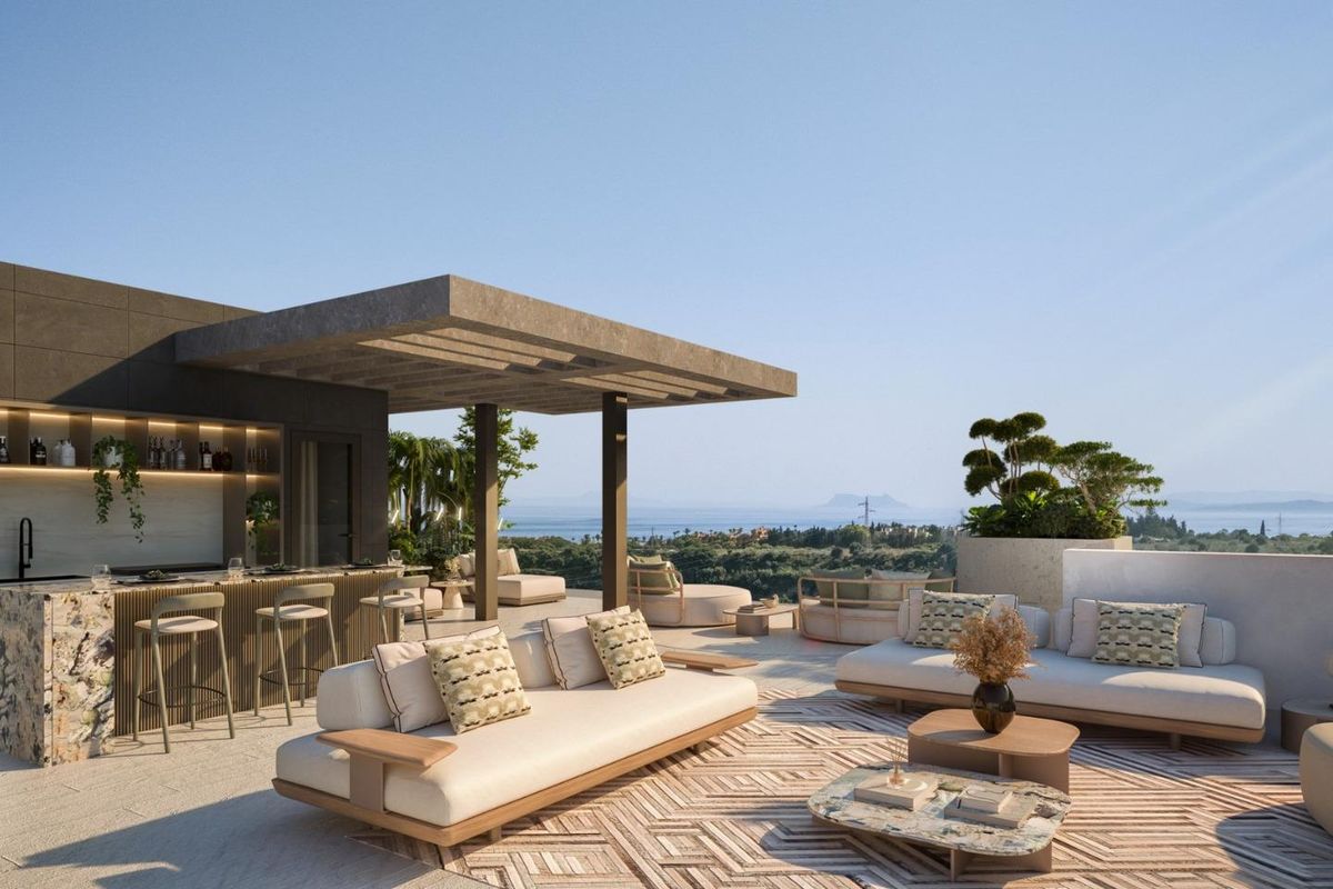 Adembenemend dakterras met zitplaatsen en een bar in een penthouse in Estepona, met uitzicht op de omgeving.