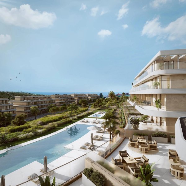 Uitzicht op het gemeenschappelijke zwembad en aangelegde tuinen van een modern appartementencomplex in Estepona, Costa del Sol.