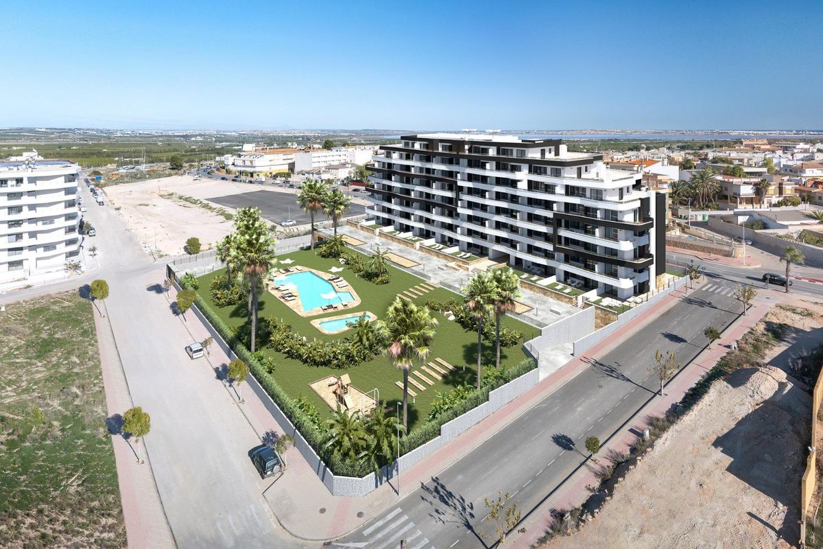 Luchtfoto van het appartementencomplex, met nadruk op de omliggende straten en tuinen in San Miguel de Salinas.