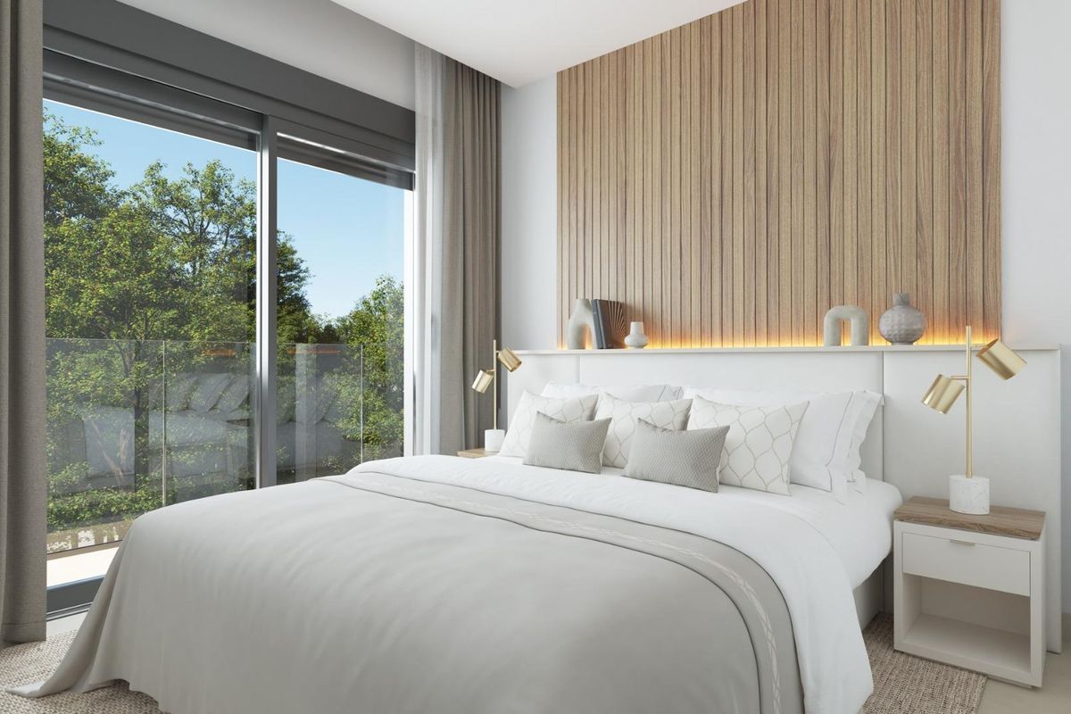 Moderne slaapkamer met uitzicht op bomen in een 3-slaapkamer herenhuis, Mijas, Costa del Sol. Grote raampartij en houten hoofdbord.