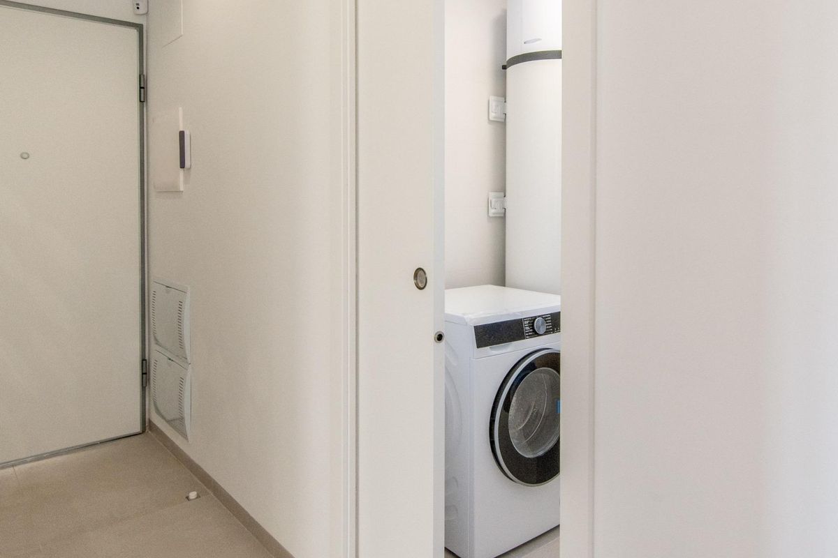 Wasruimte met een wasmachine, gelegen in het 3-slaapkamer penthouse in Finestrat, Costa Blanca.