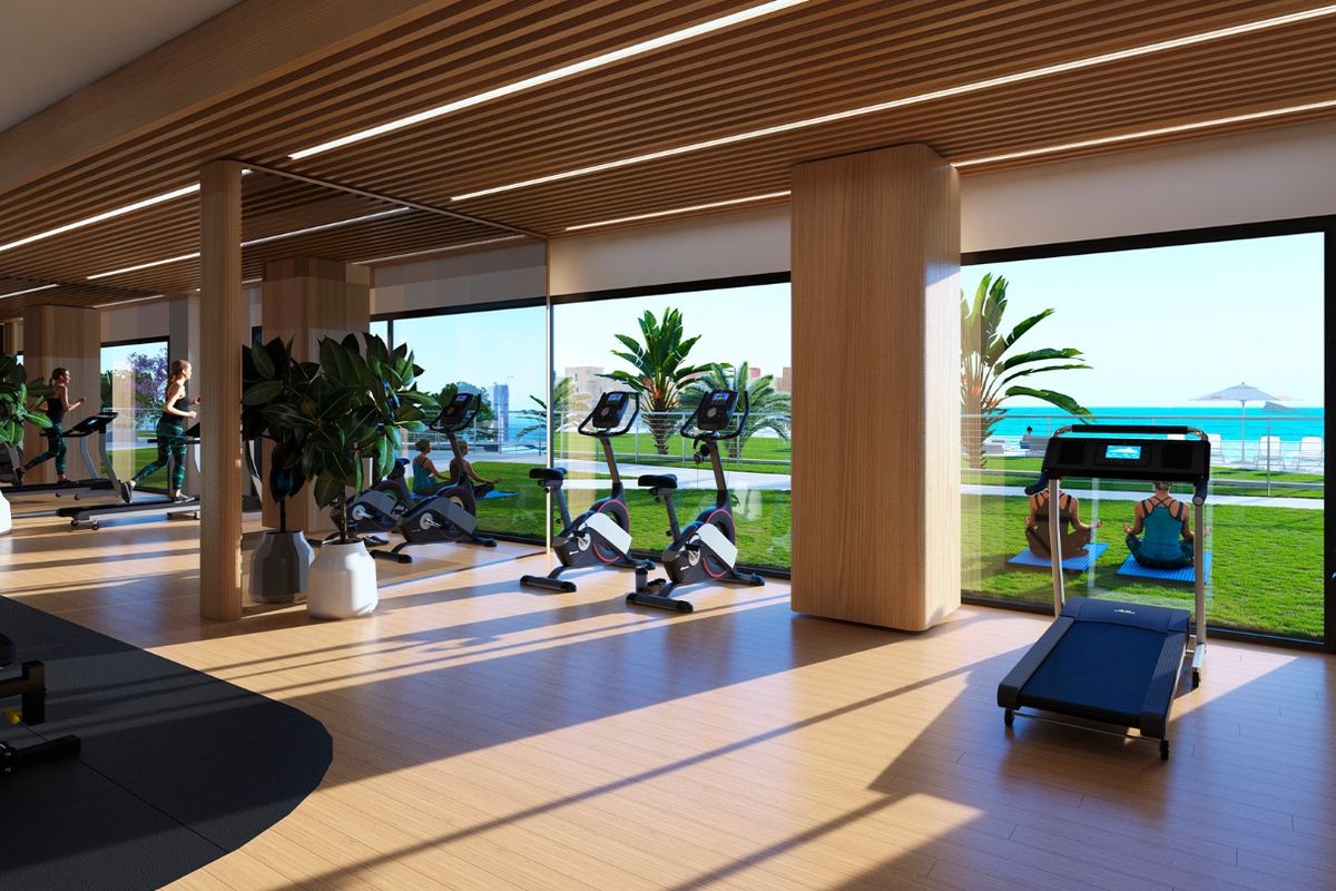 Moderne fitnessruimte met uitzicht op zee, uitgerust met verschillende fitnessmachines in Benidorm.