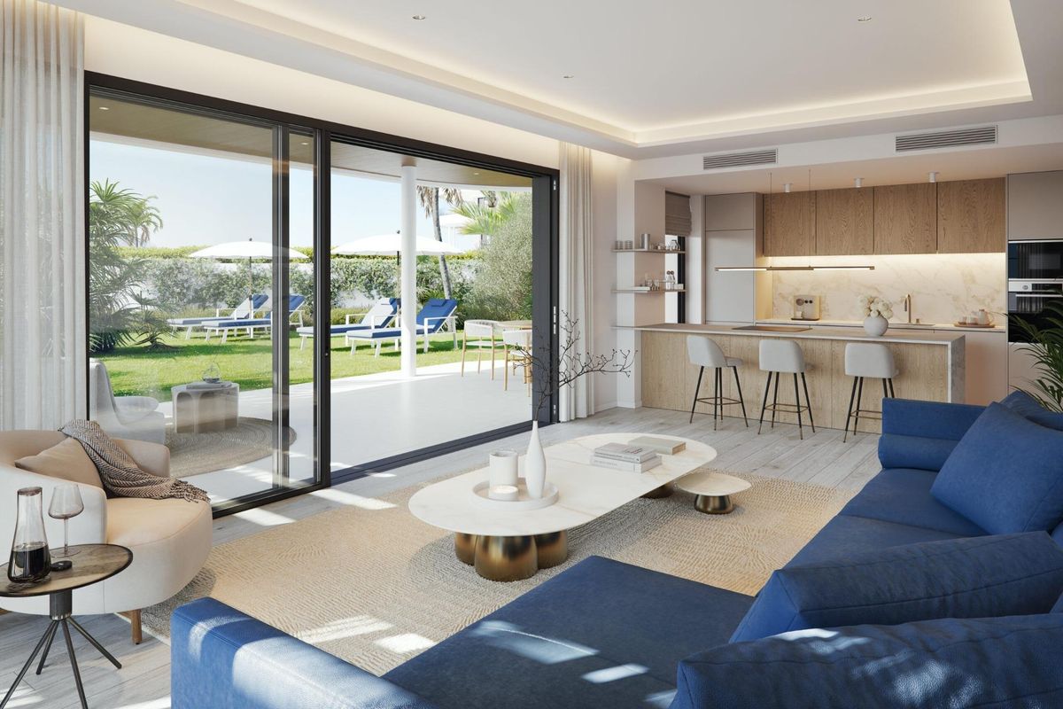 Gezellige woonkamer in een 3-slaapkamer appartement in Mijas, die uitkomt op een zonnig terras met tuinzicht.