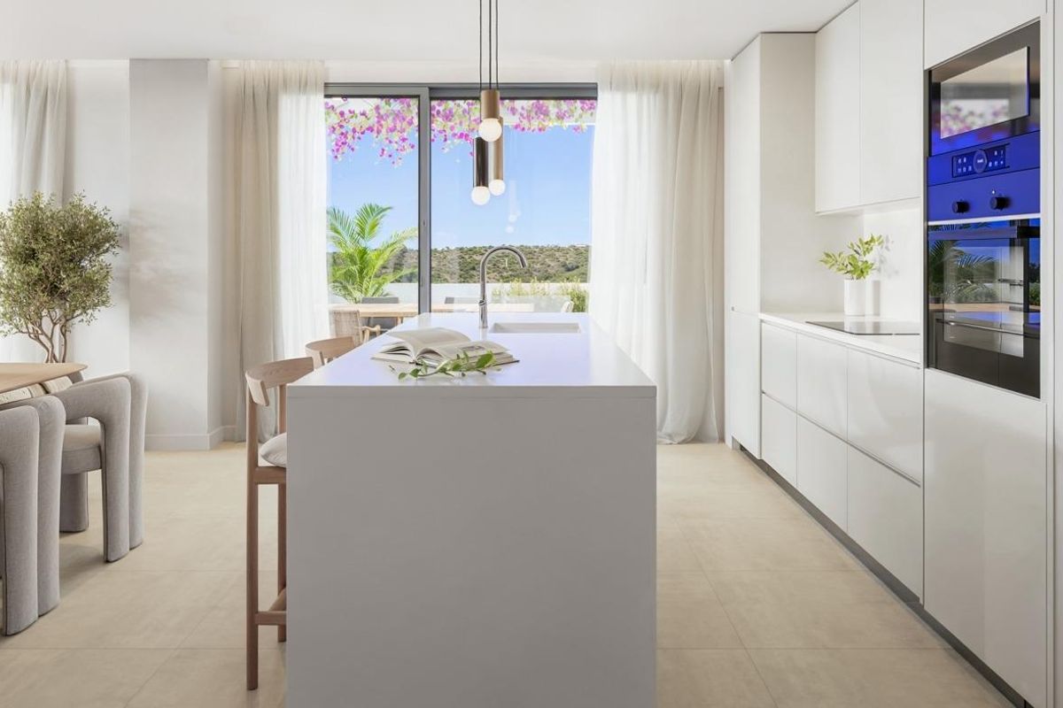 Heldere keuken met moderne apparaten en eetruimte, gelegen in een appartement op de begane grond in Casares, Spanje.