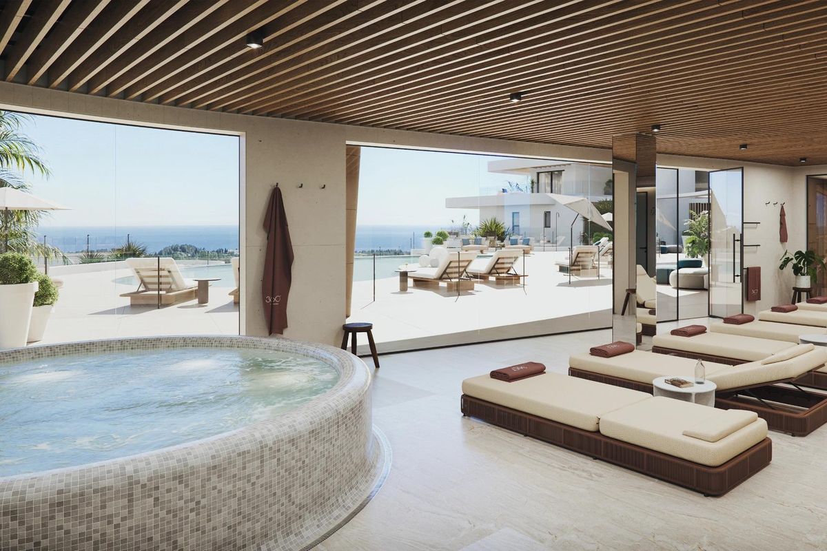 Elegante loungruimte met een hot tub en uitzicht op de oceaan in een resort in Mijas, Costa del Sol.