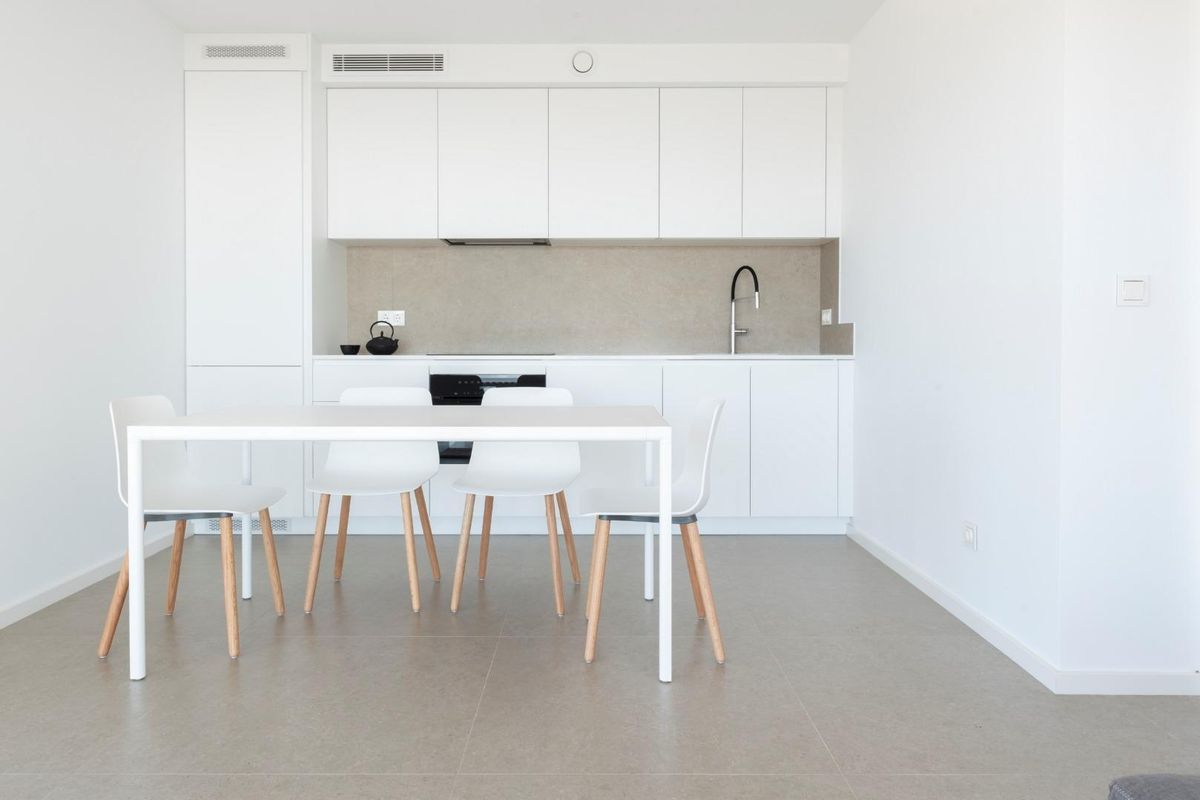 Sleek white kitchen and dining area in a modern villa located in Benitachell, Costa Blanca.