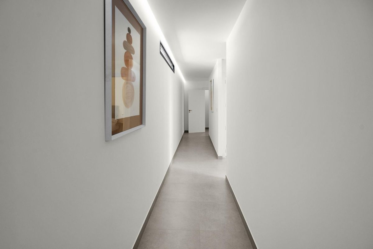 Lang gangpad met een minimalistisch ontwerp en kunstwerk, door een villa in Baños y Mendigo, Spanje.