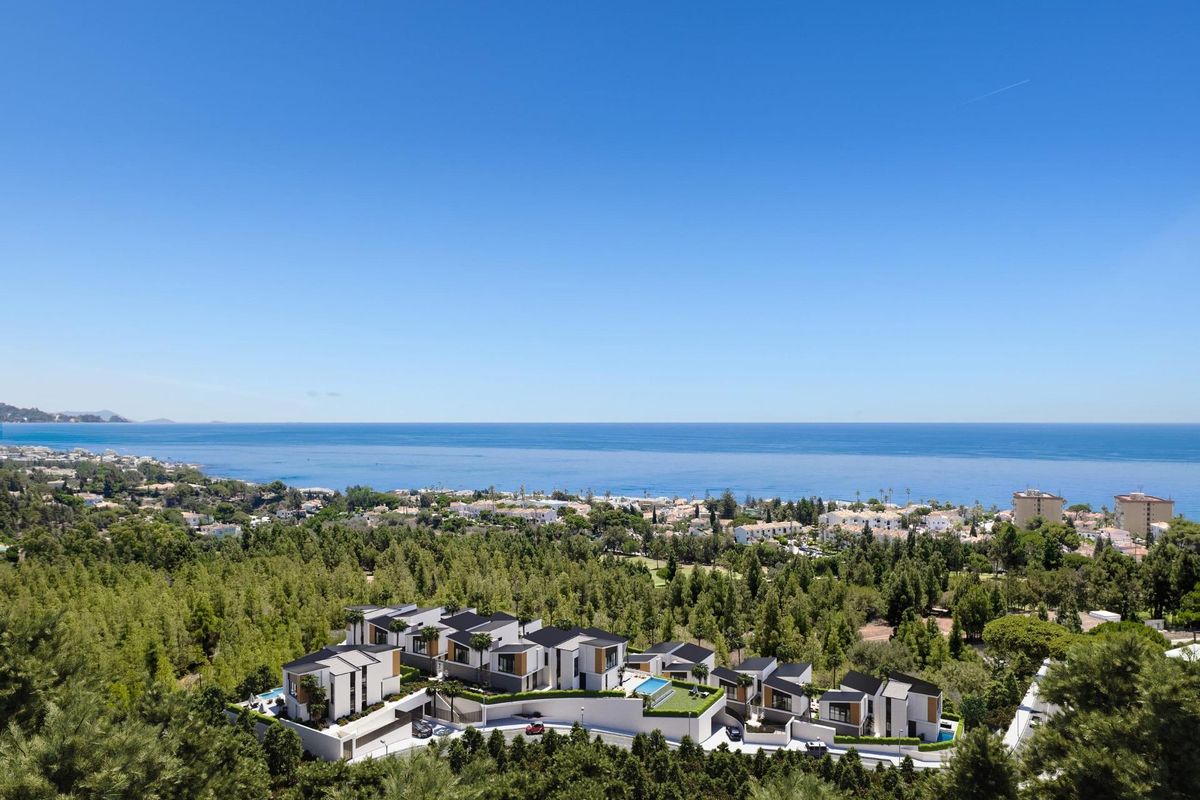 Luchtfoto van een moderne villa gemeenschap in Mijas, Costa del Sol, met uitzicht op de zee en bergen.