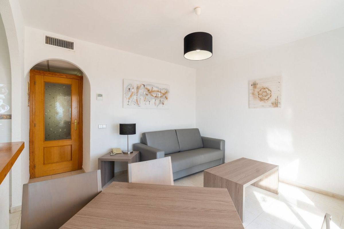 Eenvoudige woonkamer met natuurlijk licht en hedendaags design in een 1-slaapkamer bungalow in Calpe.
