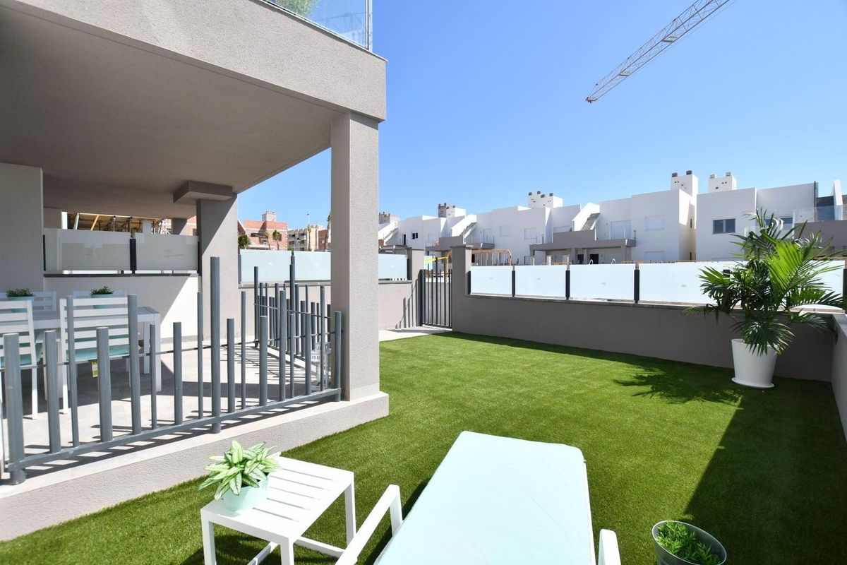 Heldere terrasm van het appartement met comfortabele zitplaatsen en een groen gazon in San Miguel de Salinas.