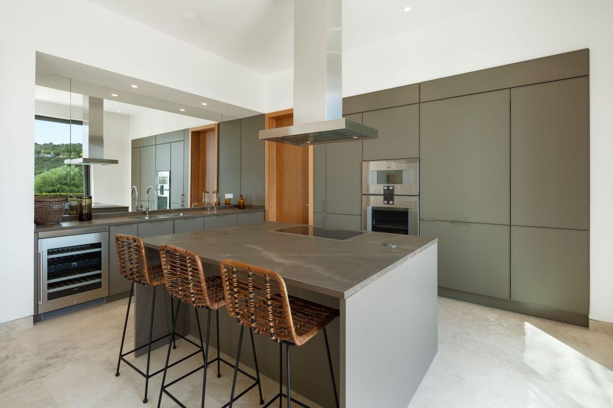 Strakke en moderne keuken met een kookeiland en premium apparatuur in de villa in Casares, Costa del Sol.