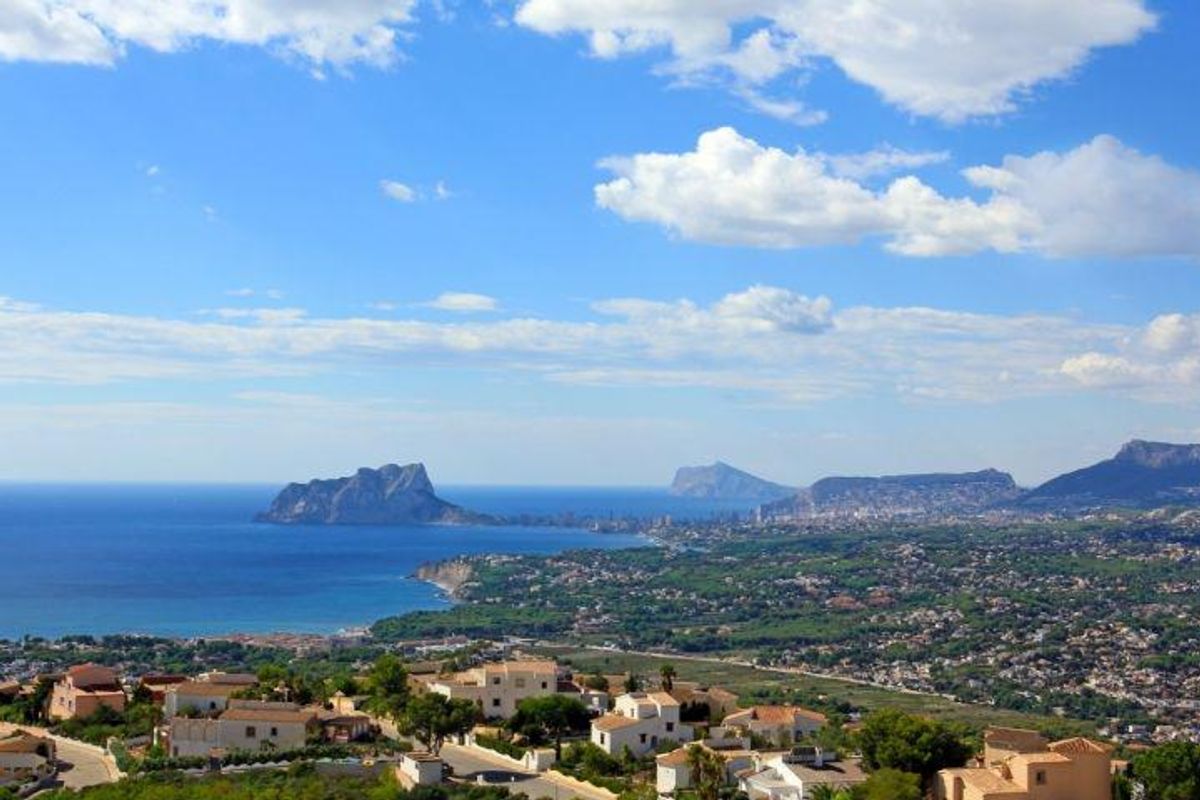 Schilderachtig uitzicht op het landschap van Benitachell met kustbergen, zee en woongebieden.