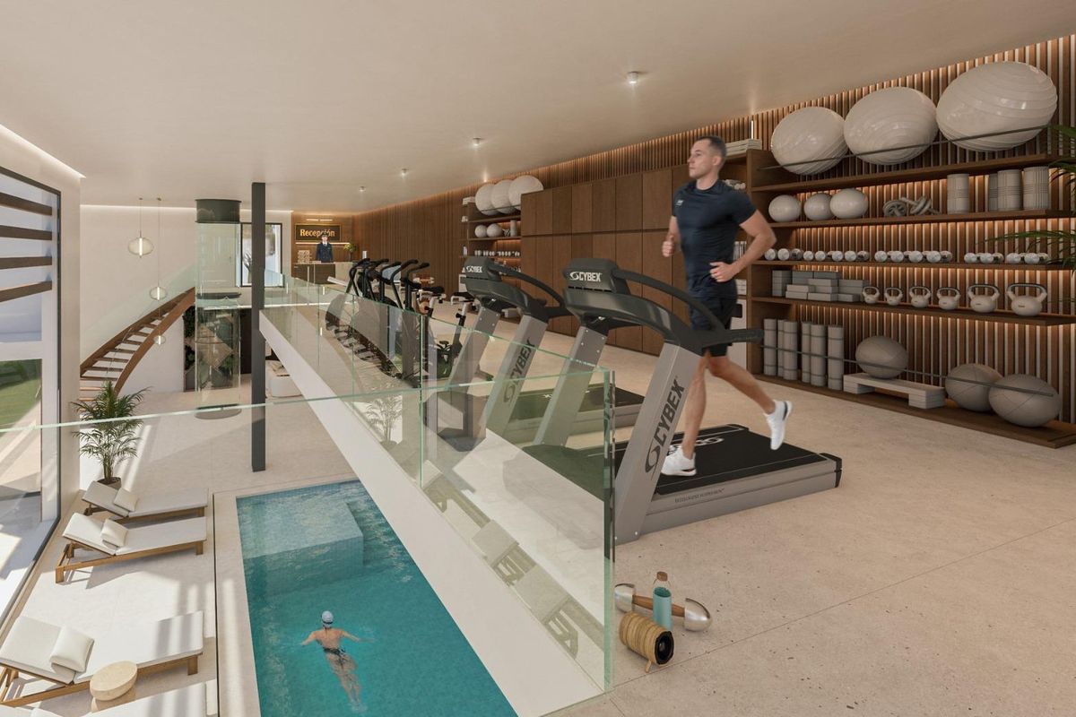 Binnen fitnessruimte met loopbanden met uitzicht op een binnenzwembad in een luxe complex in Marbella.
