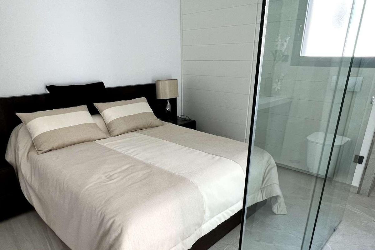 Stijlvolle master slaapkamer in een villa in Rojales met elegante inrichting en een aangrenzende moderne badkamer.