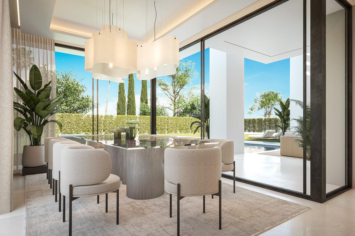 Eetkamer van een moderne villa in Estepona met een grote eettafel en stoelen. Uitzicht op de tuin en het zwembad.