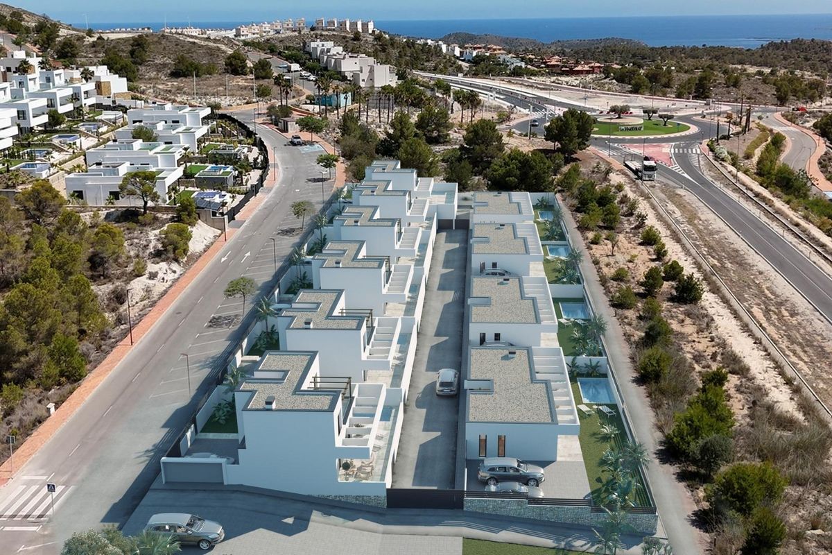 Aerial view of a villa community in Finestrat, showcasing modern designs and proximity to the coastline.