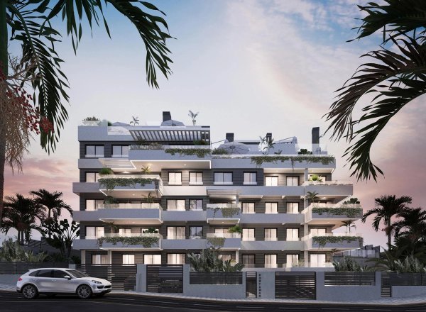 Buitenzicht op een stijlvolle penthouse met 3 slaapkamers in Estepona, met moderne architectuur en weelderige begroeiing.