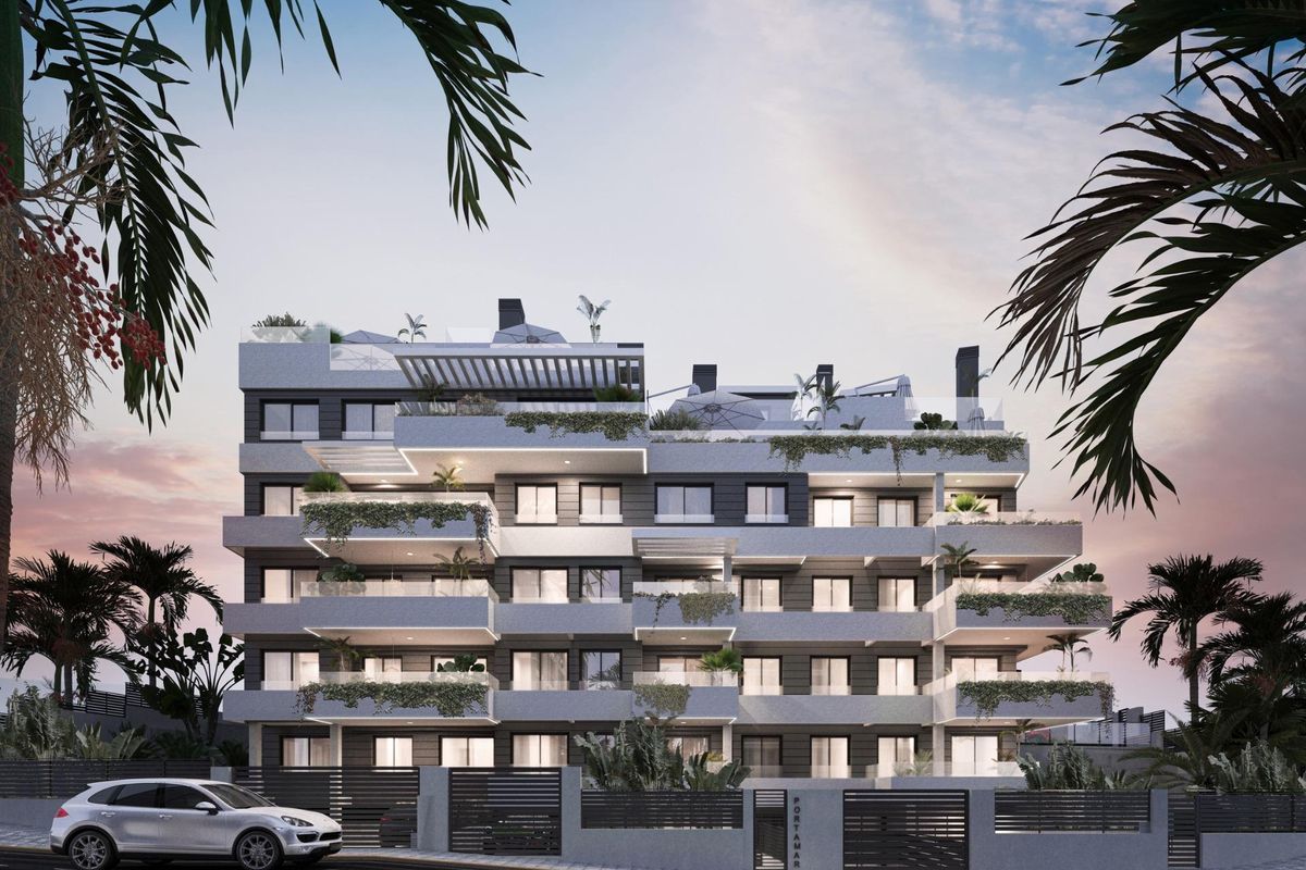 Buitenzicht op een stijlvolle penthouse met 3 slaapkamers in Estepona, met moderne architectuur en weelderige begroeiing.