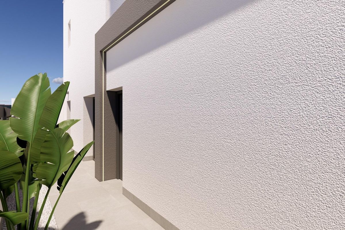 Zijzicht op de moderne gevel van een 3-slaapkamer townhouse in Benijofar, met ontwerpdetails en planten.