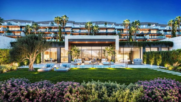 Buitenzicht op een modern penthouse in Manilva, met weelderig groen en een zwembadgebied.