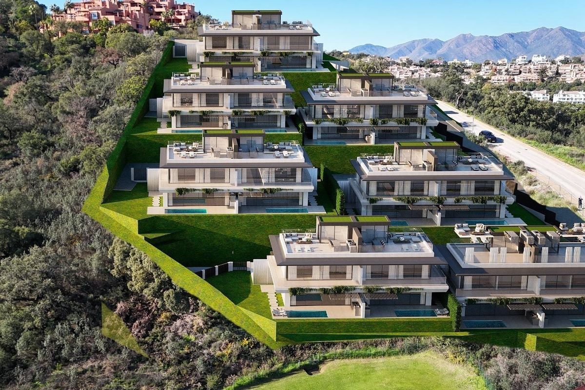 Luchtfoto van hedendaagse townhouses op een heuvel in Ojen, met groene terrassen en een prachtig uitzicht.