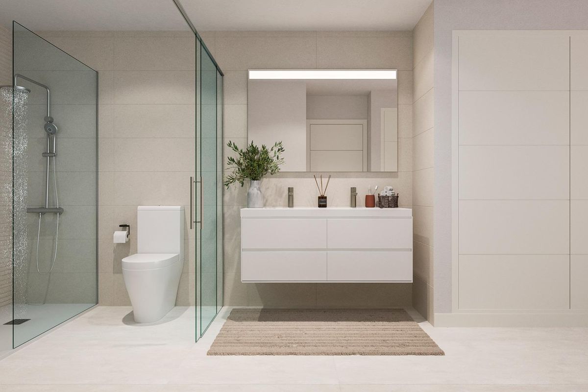 Moderne badkamer met een inloopdouche en stijlvolle witte kasten in een appartement op de begane grond in Estepona.