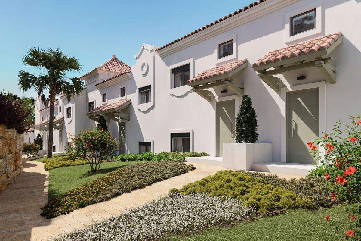 Charmante buitenkant van het appartementencomplex omgeven door groene tuinen in Estepona.